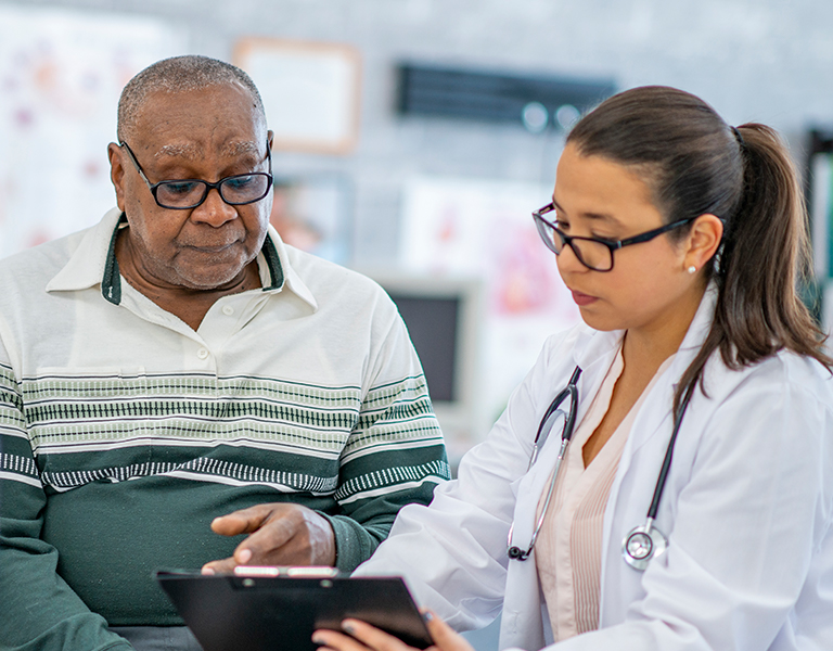 Doctor showing senior patient a tablet